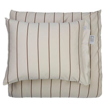 A beige pillowcase with vertical brown stripes, shown layered over a matching duvet cover on a plain white background.