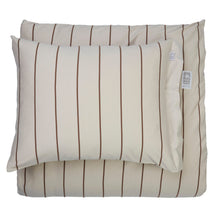 A beige pillowcase with vertical brown stripes, shown layered over a matching striped folded duvet