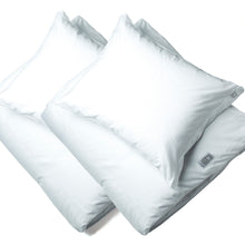 Two white pillows resting on folded white jersey bedding, photographed on a clean white background.