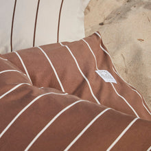 Striped jersey bedding in brown and beige on a sandy beach